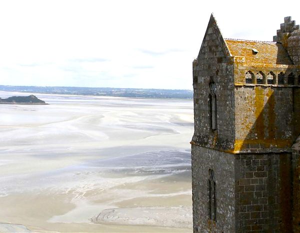 Одна из апсид монастыря Мон Сен-Мишель увенчана покатой крышей и дополнена трехстворчатыми окнами, украшенными каменными переплетами в виде клевера.