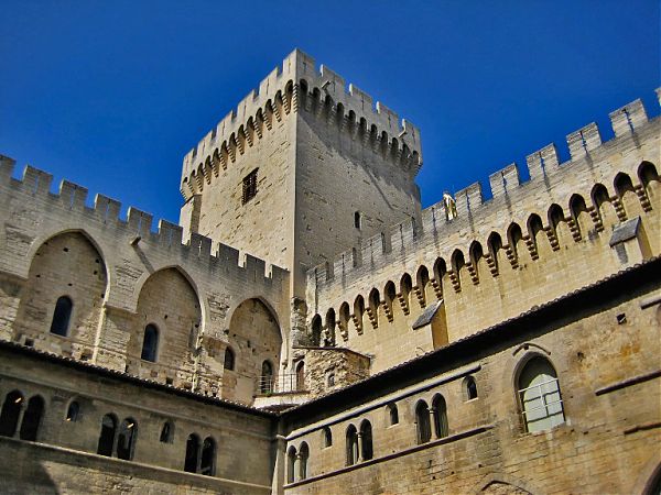 Одна из угловых башен Нового папского дворца, от которой расходятся крытые галереи, увенчана плоскими зубцами-мерлонами, ступенчатыми бойницами и широкой смотровой террасой.