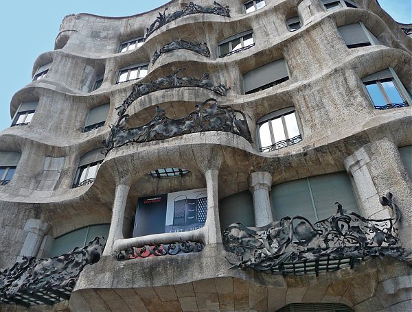 Криволинейный фасад Дома Мила выполнен из железобетона и блоков известняка, а балюстрады украшены коваными металлическими решетками, напоминающими виноградную лозу.