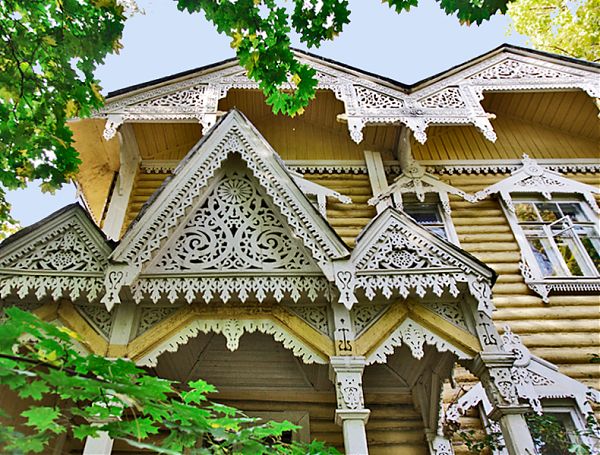 Фронтон деревянного дома полностью покрыт резным декором (накладная пропильная резьба).