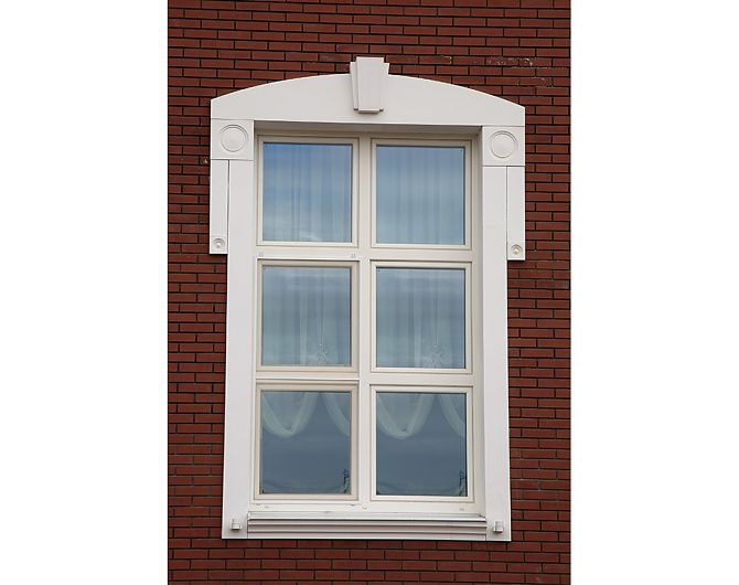 Розетки и сандрик в обрамлении окна