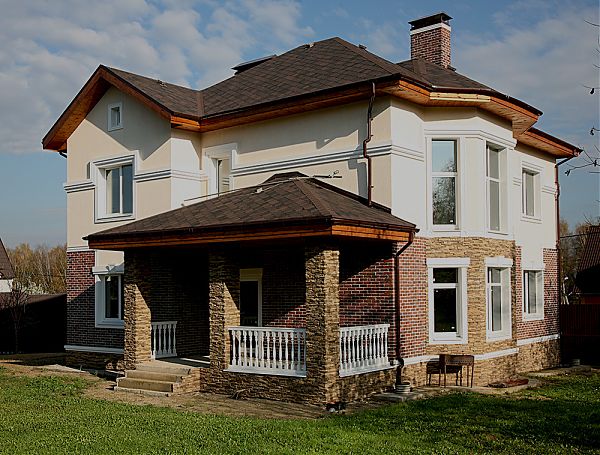 Отделка цоколя фасада и крыльца выполнена из рустованного камня, что добавляет облику дома строгость.