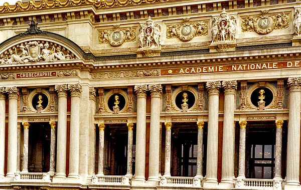 Один из боковых портиков Дворца Гарнье дополнен полукруглым фронтоном, в нише которого располагается барельеф с изображением нимф и муз.