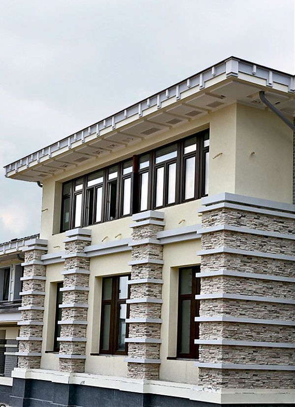 Отделка декоративным камнем дома в Поздняково подчеркивает строгие геометрические формы строения.