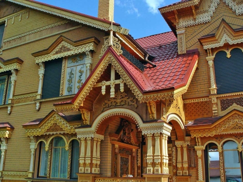 На фото - резные пропильные узоры на фасаде современного дома.