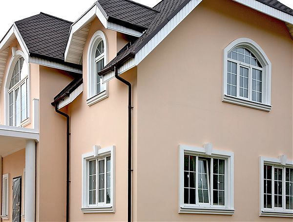 Замковые камни в обрамлении окон дома, фасадный декор из полиуретана