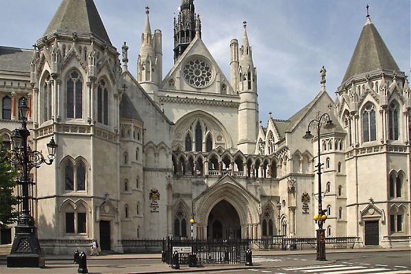 Центральный фасад Королевского суда Лондона дополнен массивными арочными воротами и двумя выступающими башнями, увенчанными крышами с острым завершением.
