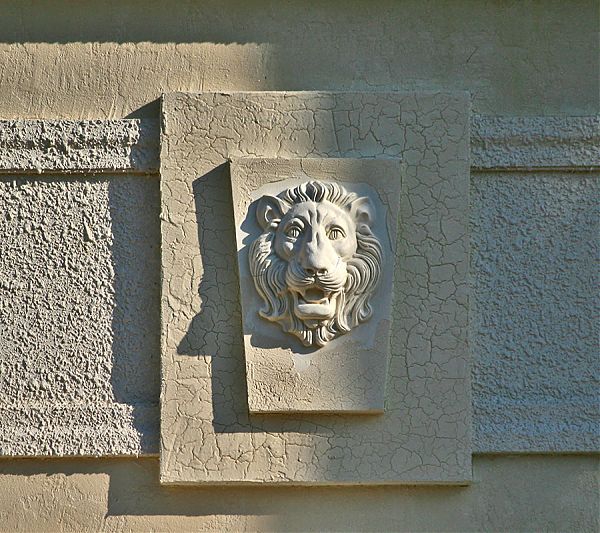 Голова льва на барельефе из полиуретана для украшения фасада дома.